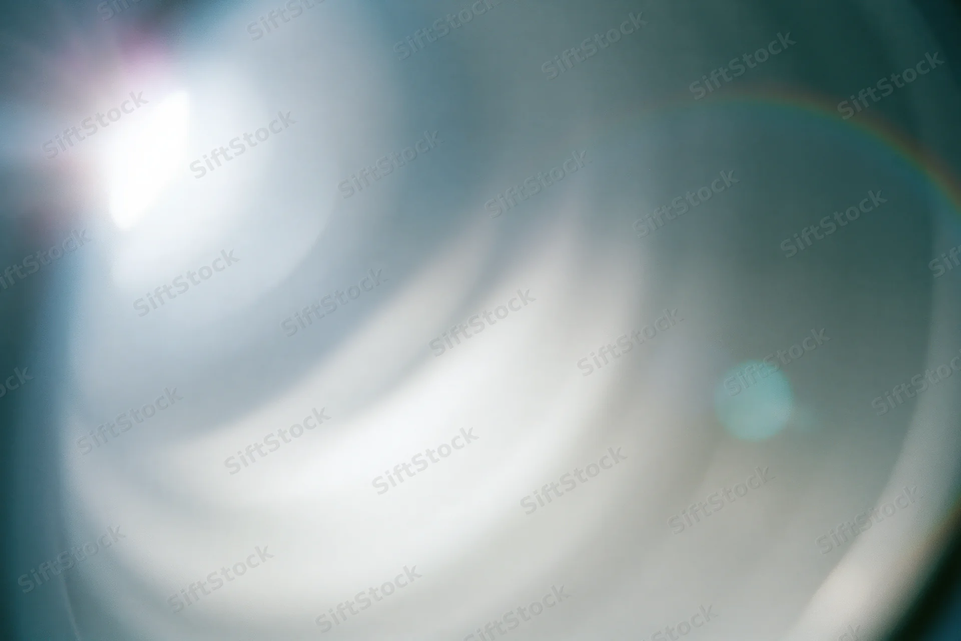 Close-up of a camera lens element showing light flare and reflections