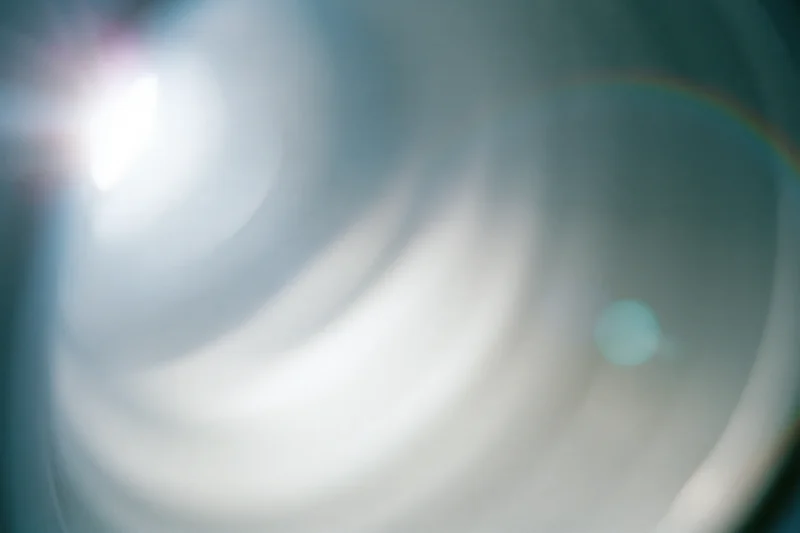 Close-up of a camera lens element showing light flare and reflections