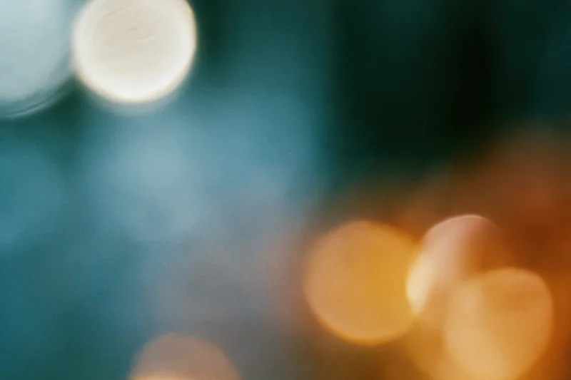 Blurred circular lights in warm and cool tones creating a soft bokeh background