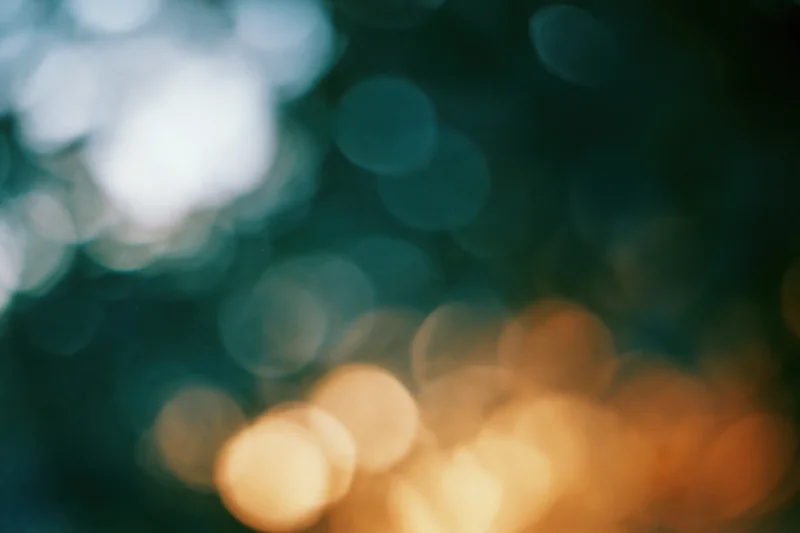 Blurred circular lights in warm and cool tones against a dark background