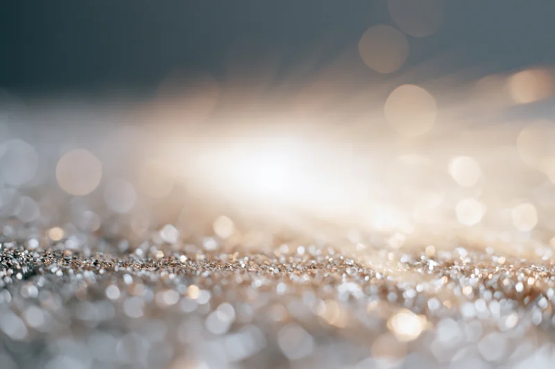 Glittering surface with sparkling bokeh lights in soft focus, creating a festive abstract background