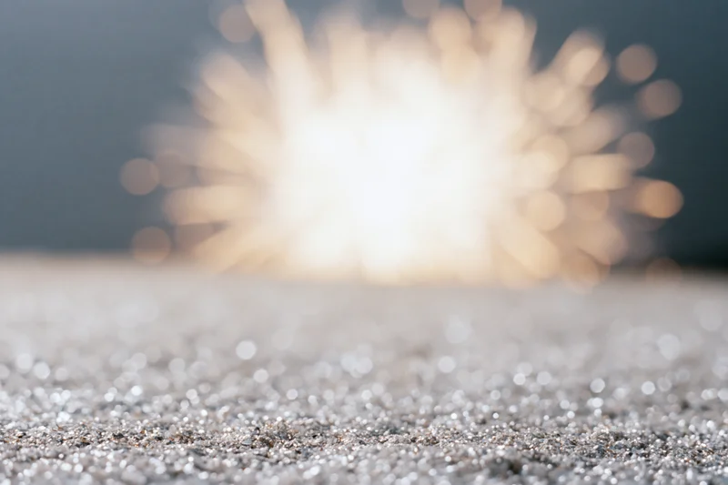 Fireworks bursting in the night sky with bokeh lights above a glittering textured surface