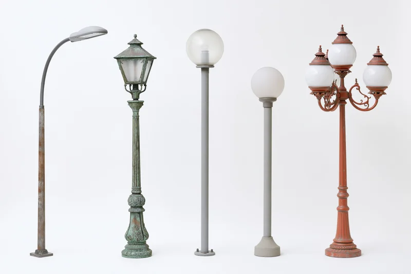 Five street lamp posts arranged side by side against a plain white background