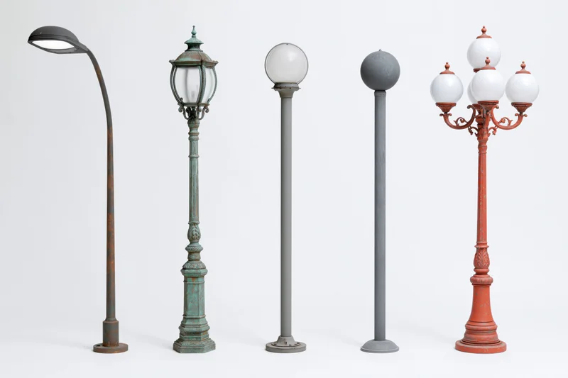 Five different street lamp posts arranged side by side against a plain white background