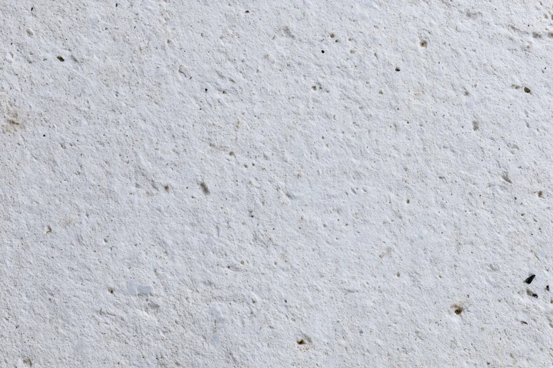 Flat concrete wall surface filling the frame with rough texture and small imperfections