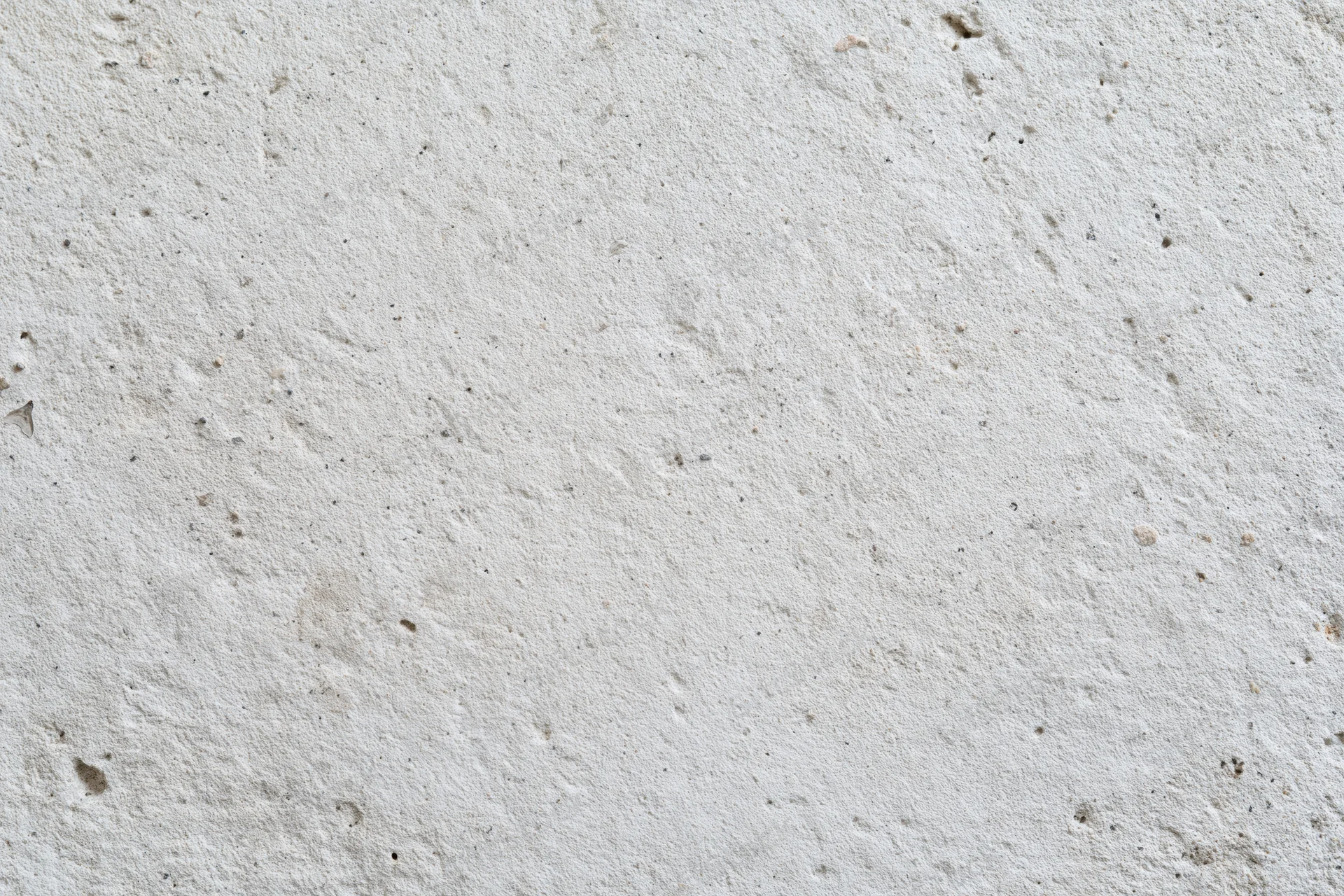 Flat concrete wall surface filling the frame with rough texture and small imperfections