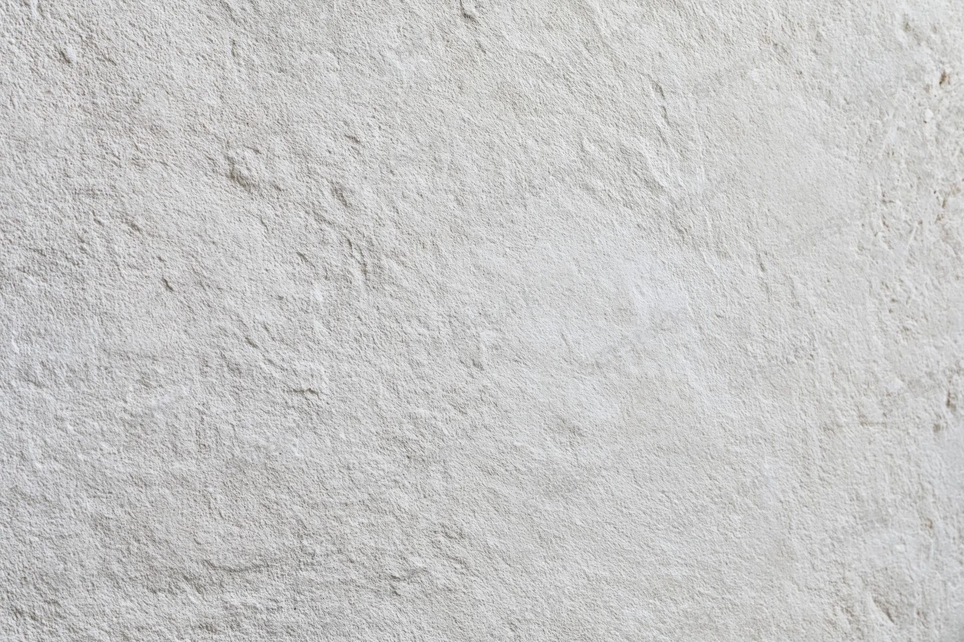 Flat concrete wall surface filling the frame with rough texture and neutral gray tone