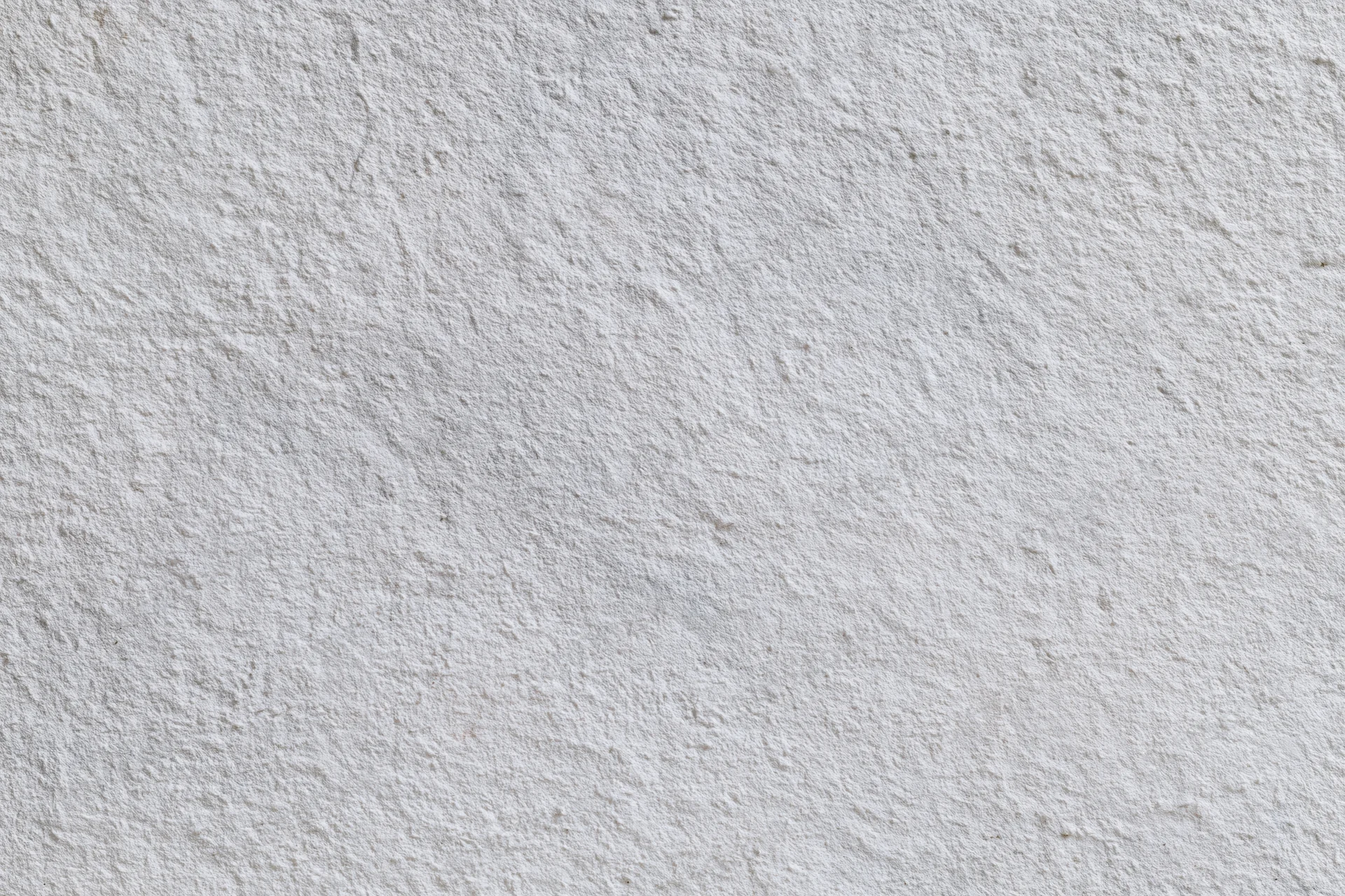 Flat concrete wall surface filling the frame with rough texture and neutral gray tone