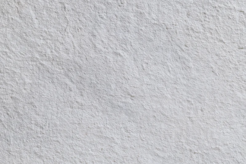 Flat concrete wall surface filling the frame with rough texture and neutral gray tone