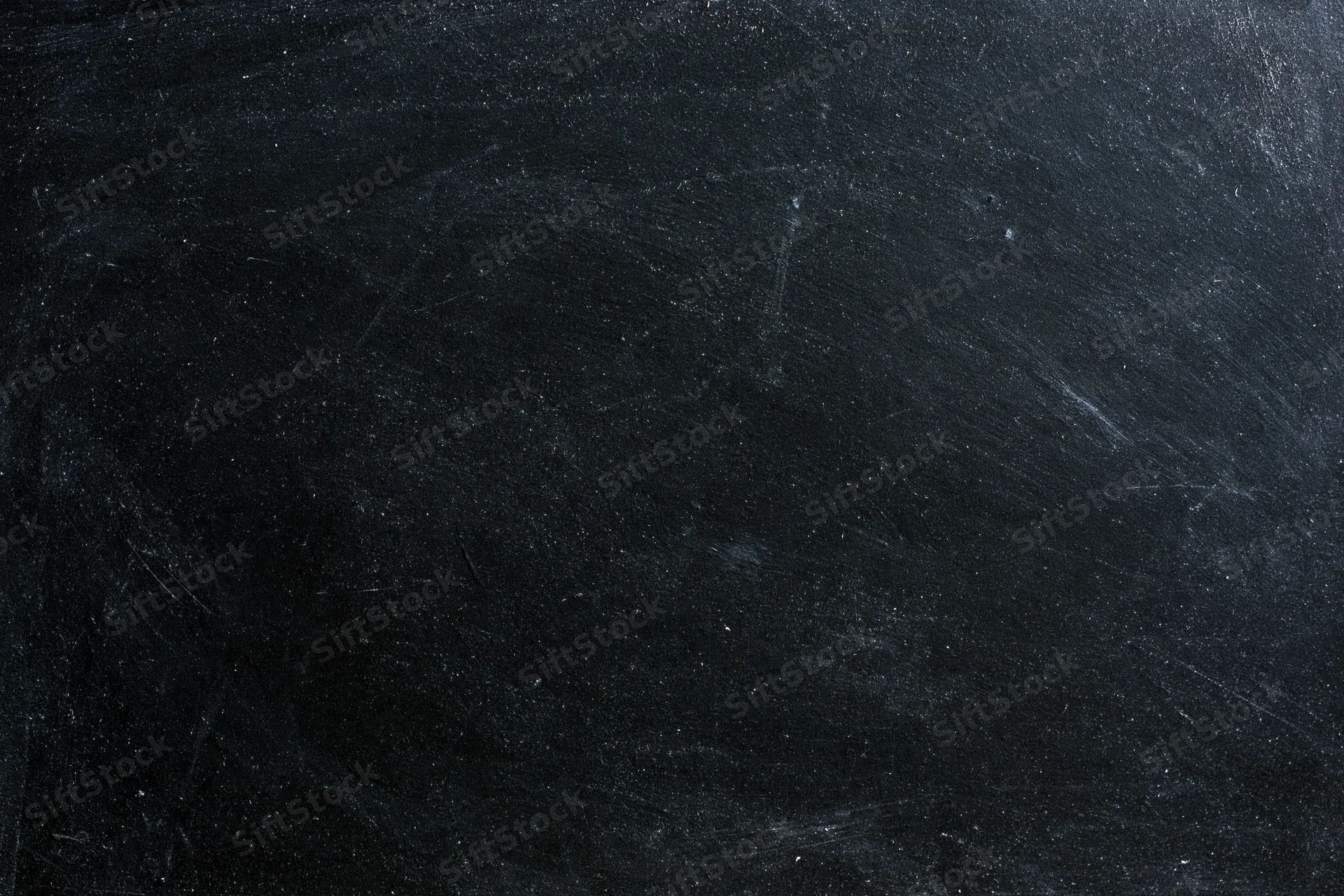 Worn black chalkboard surface with smudged chalk residue and scratches, flat lay close-up