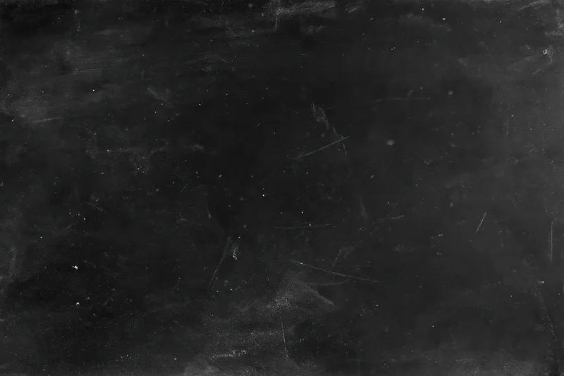 Worn black chalkboard surface with scratches and chalk residue in flat lay closeup