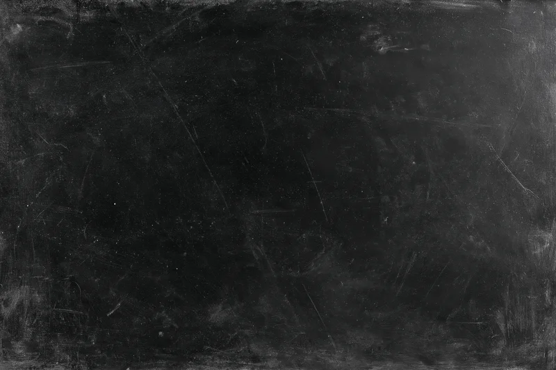 Worn black chalkboard surface with scratches and smudges, flat lay close-up, copyspace for text or design