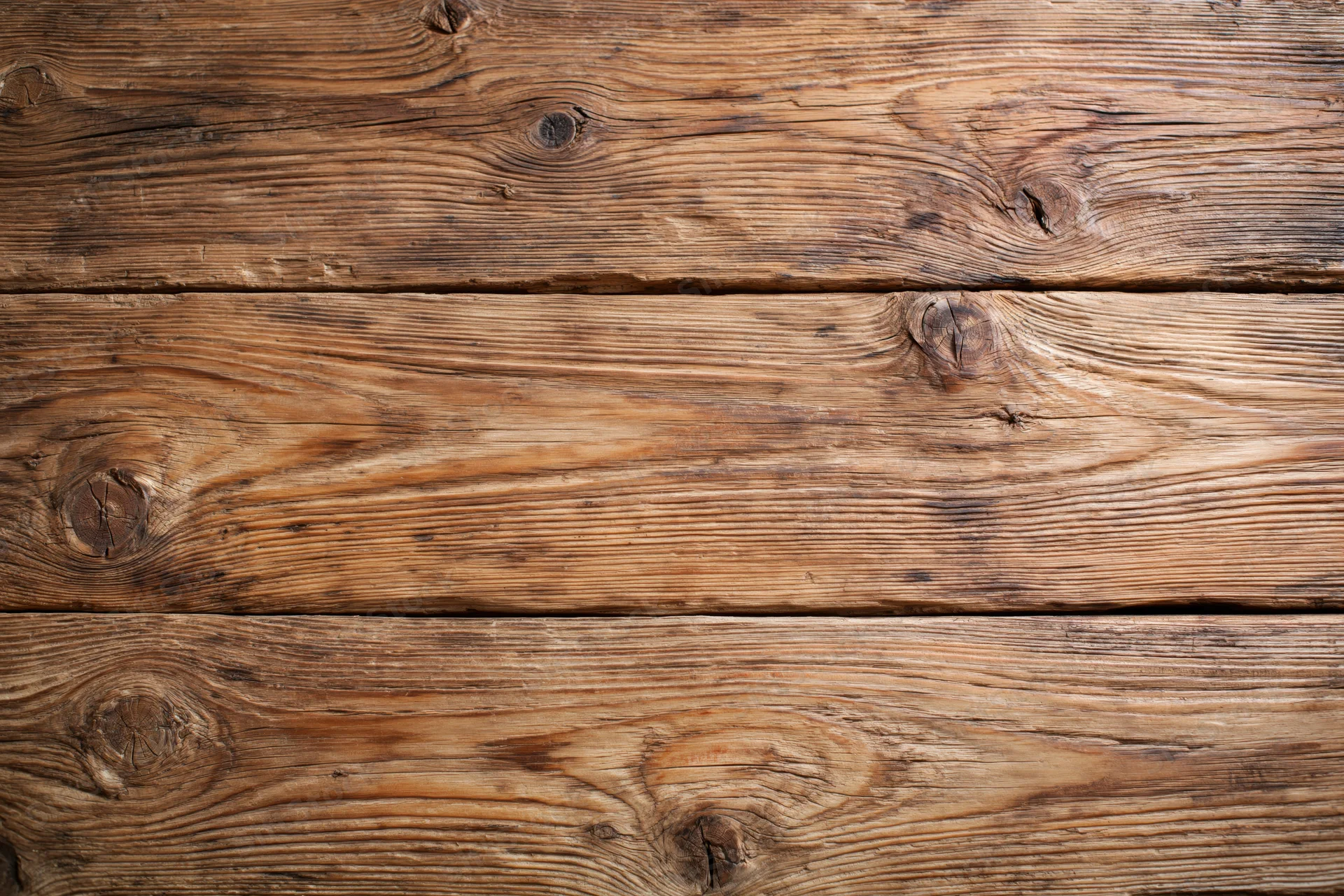 Aged horizontal wooden planks arranged in a flat lay, filling the frame with natural grain and knots