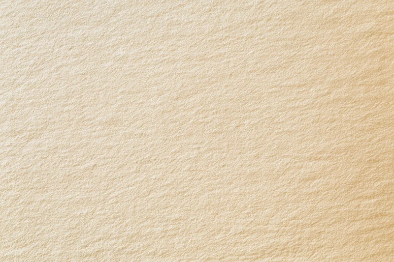 Close-up of smooth cream-colored paper surface with visible texture and fiber pattern