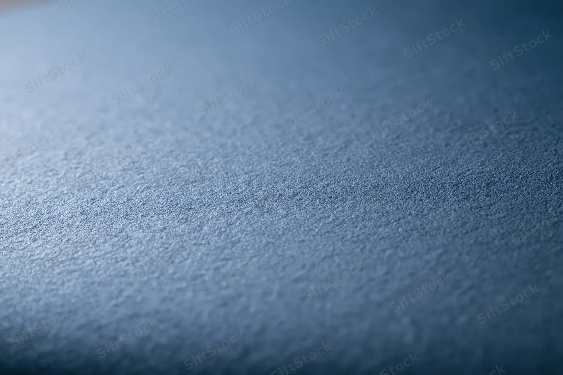 Flat matte steel-blue textured surface filling the frame as a background