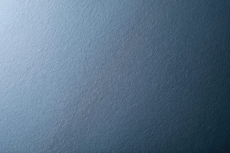 Flat matte steel-blue textured surface filling the frame