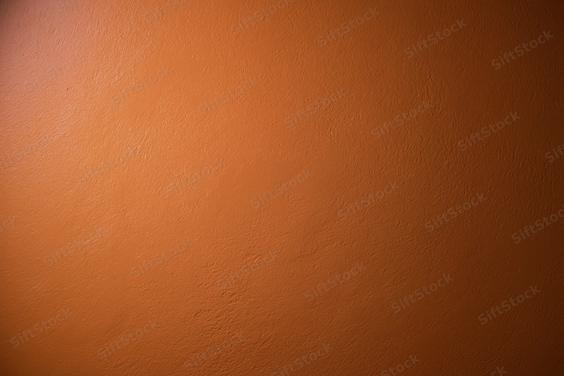 Flat orange painted wall surface filling the frame as a textured background