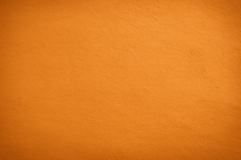 Orange painted wall surface filling the frame as a seamless background