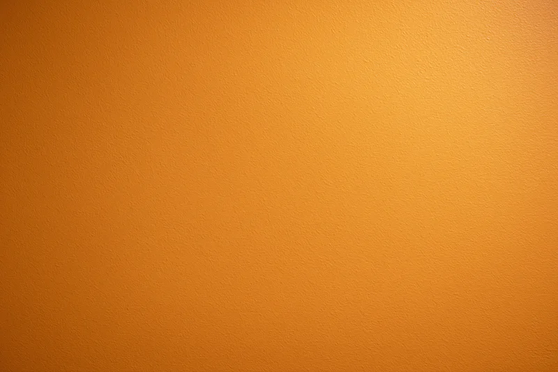 Orange painted wall surface filling the frame as a seamless background
