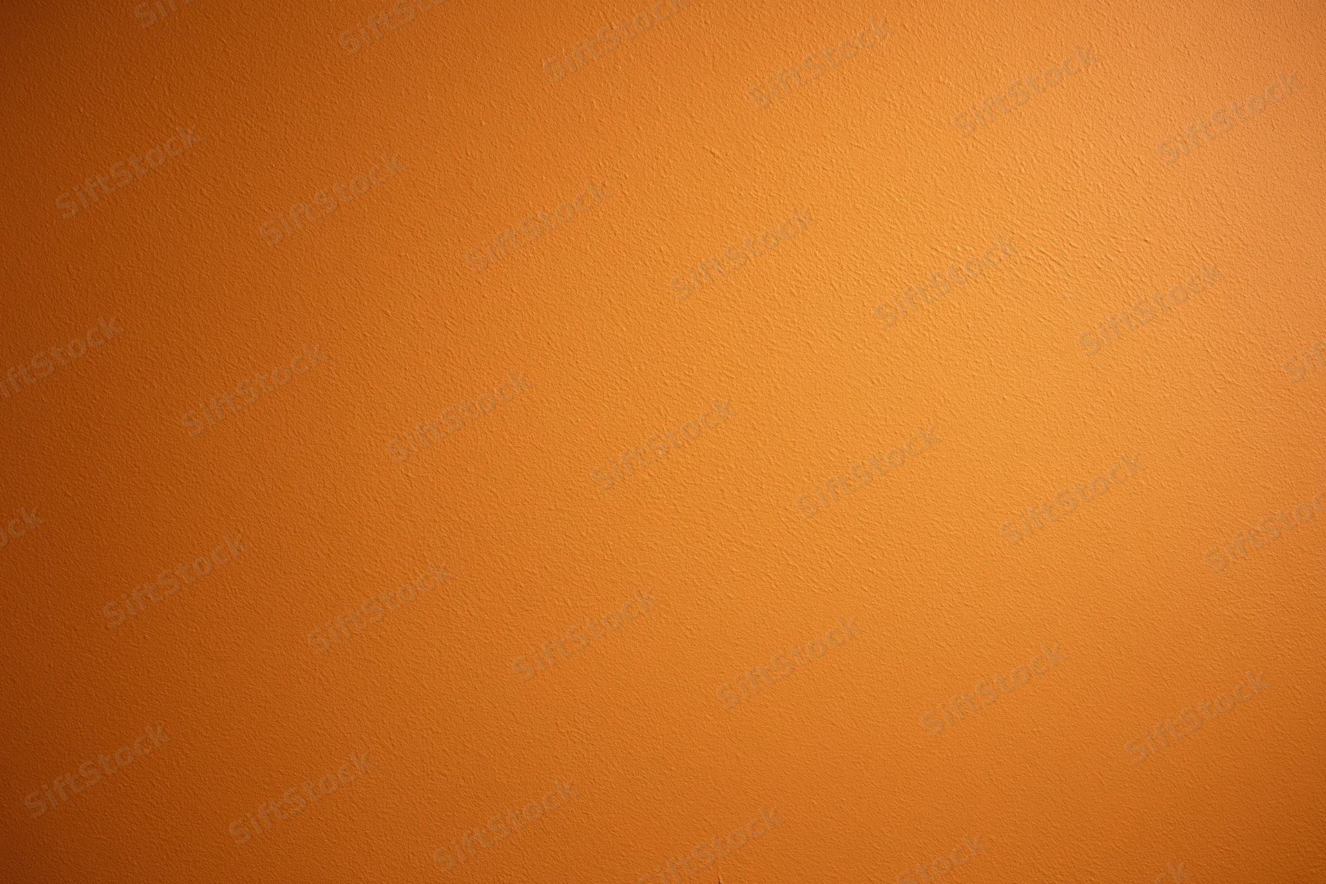 Orange painted wall surface filling the frame as a seamless background