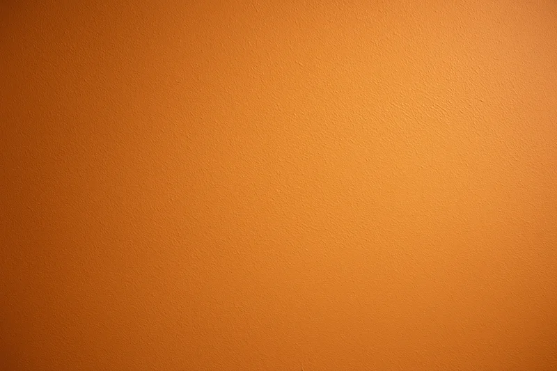 Orange painted wall surface filling the frame as a seamless background
