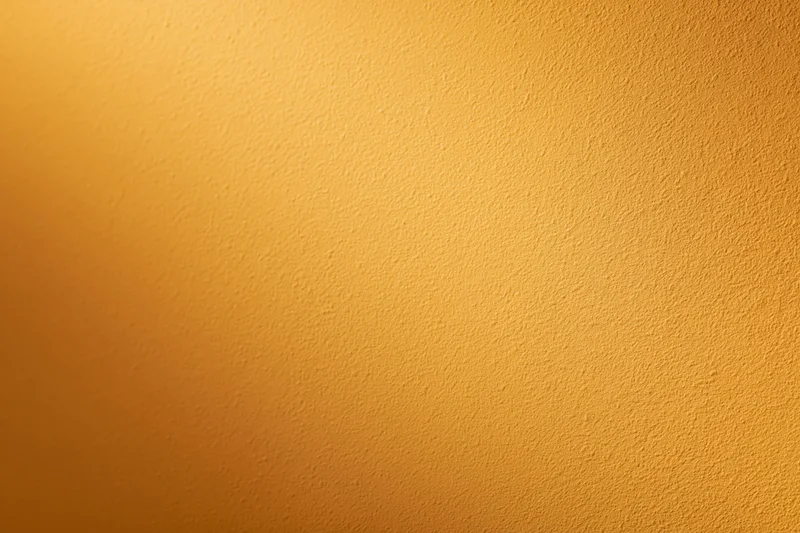 Flat orange painted wall surface filling the frame with smooth matte texture and warm gradient tone