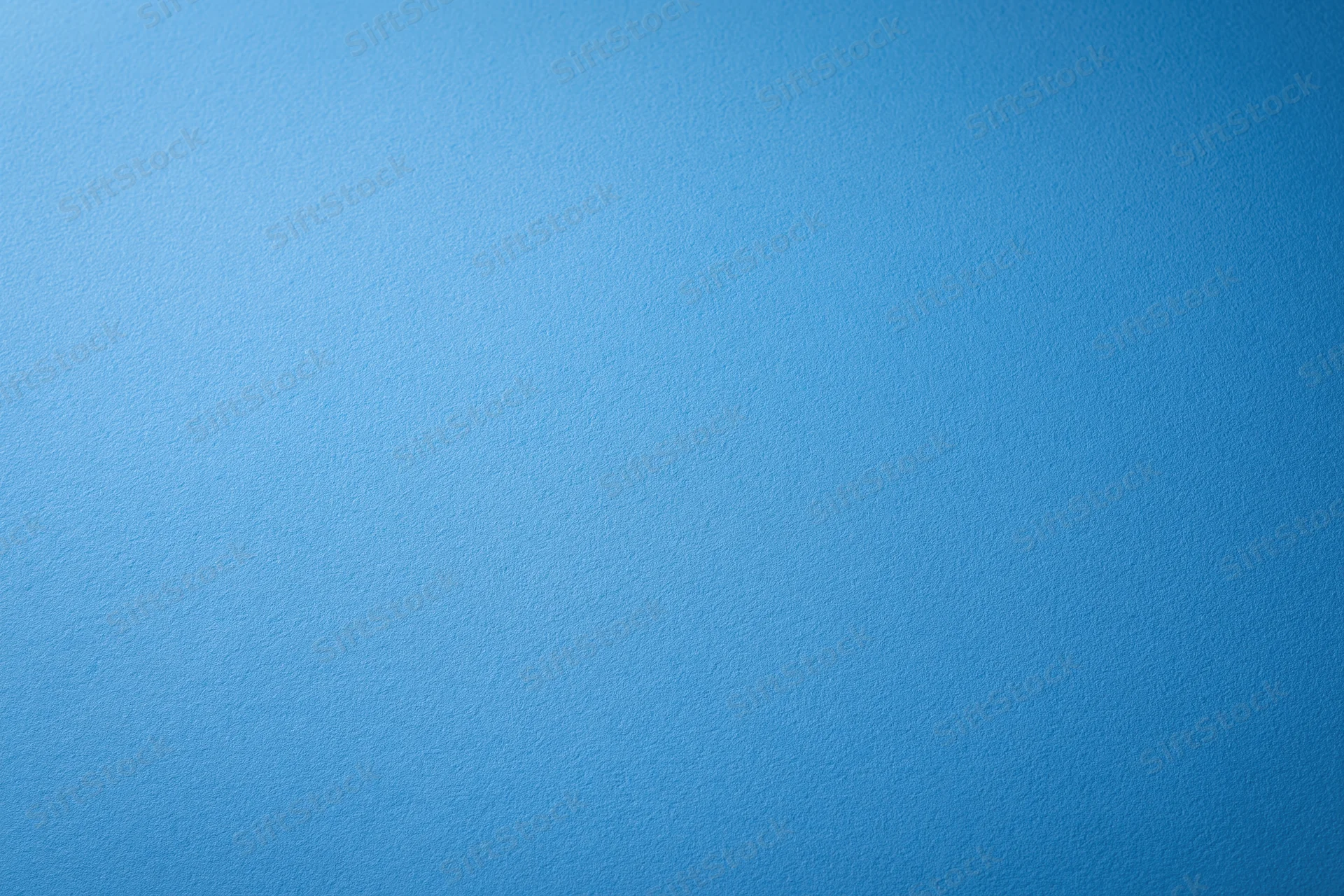 Solid blue painted wall surface filling the frame as a uniform background