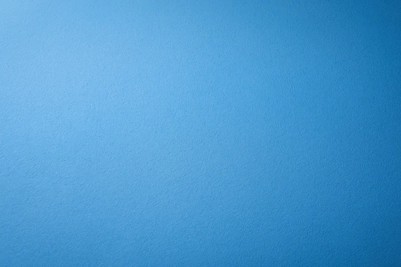 Solid blue painted wall surface filling the frame as a uniform background