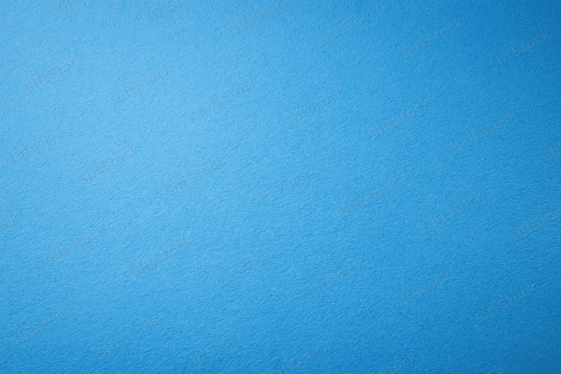 Solid blue paper or painted wall surface filling the frame as a uniform background