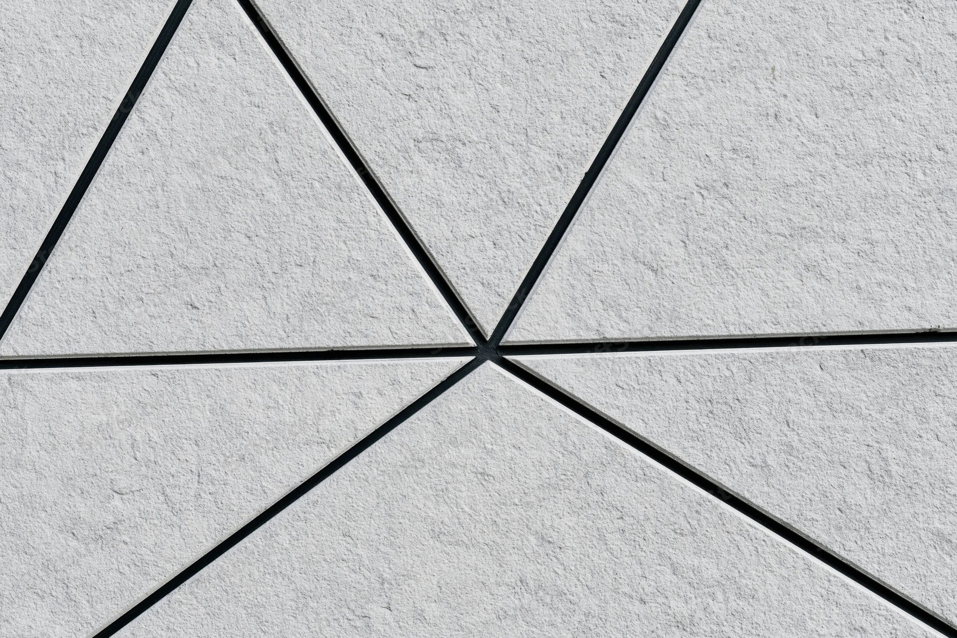Textured concrete wall divided into irregular triangular sections by black lines