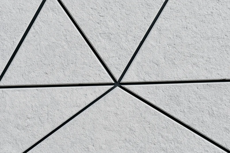 Textured concrete wall divided into irregular triangular sections by black lines