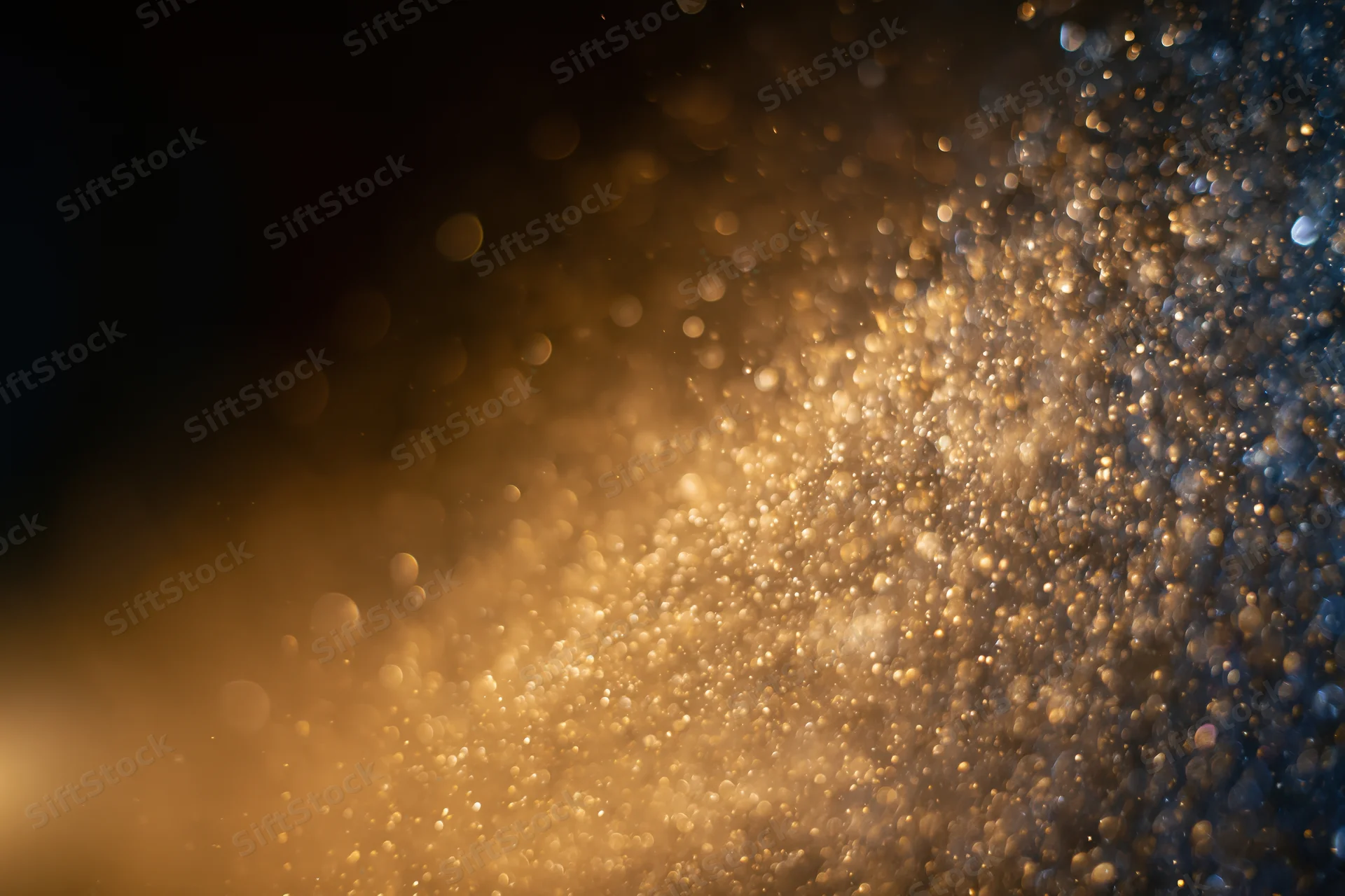 Gold dust particles and light orbs suspended midair in a warm glowing abstract background