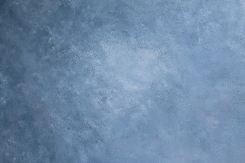 Hand-painted canvas backdrop with soft mottled blue texture for studio photography