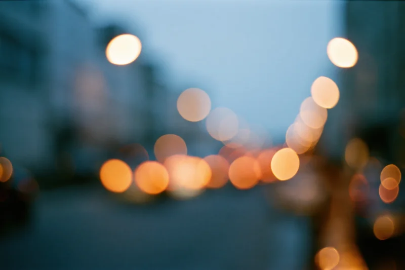 Defocused city street lights at dusk forming abstract bokeh background