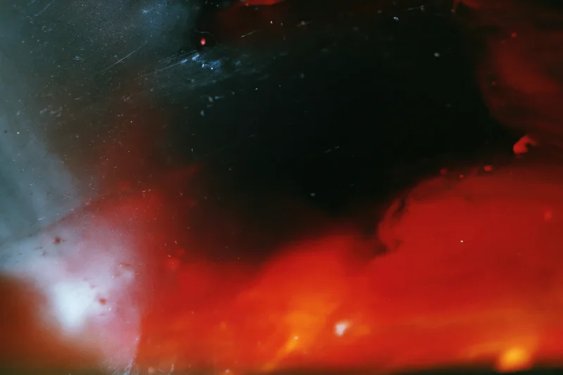 Abstract analog photograph with heavy light leaks and underexposure showing red and black color fields