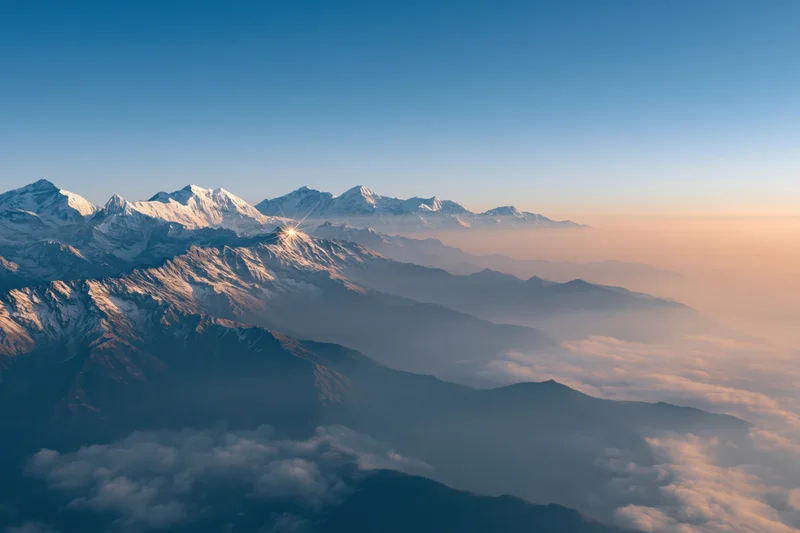 High himalayan peaks rising above a thick sea of mist at sunrise