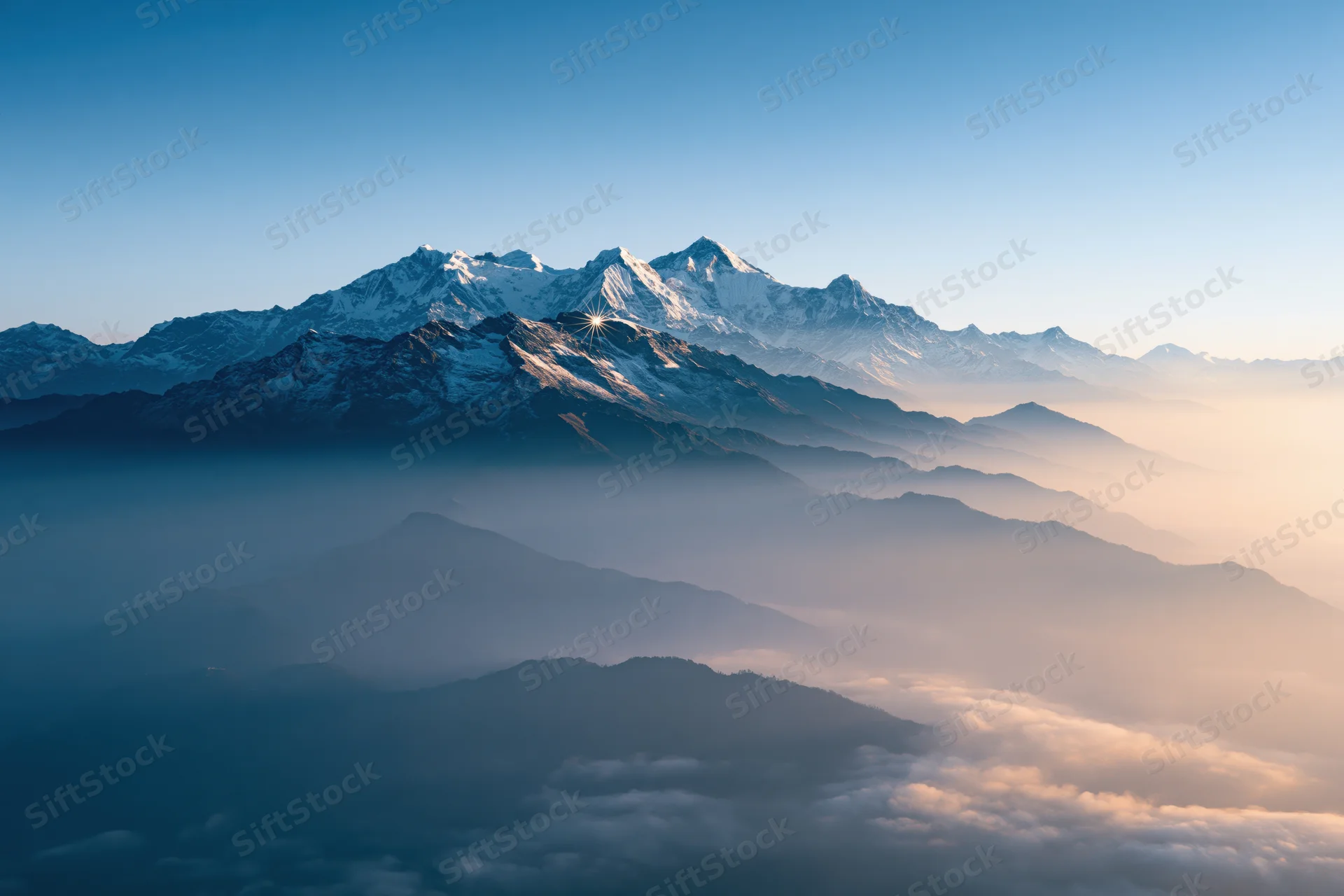Snow-capped himalayan peaks rising above a sea of mist at sunrise