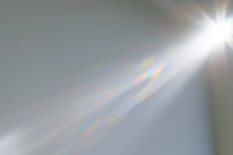 Sunlight streaming through a window onto a pale wall in a room interior