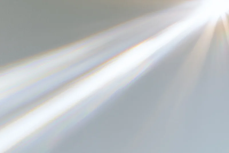 Sunlight rays streaming through a window onto a pale interior wall
