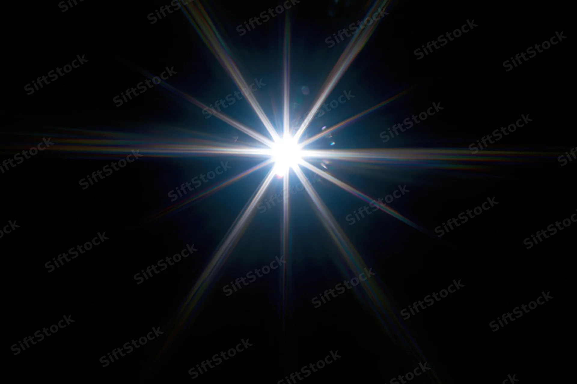 Intense white starburst lens flare centered against a pure black background