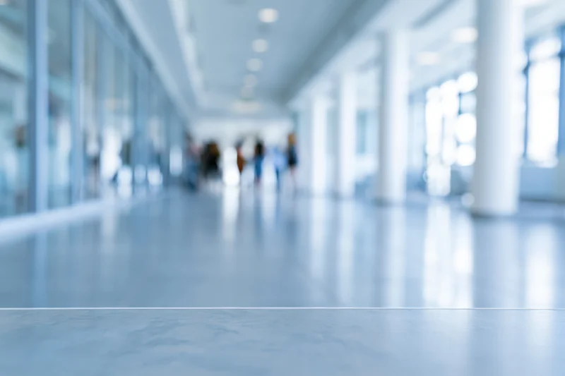 Defocused view of a modern office corridor with blurred people walking in the distance