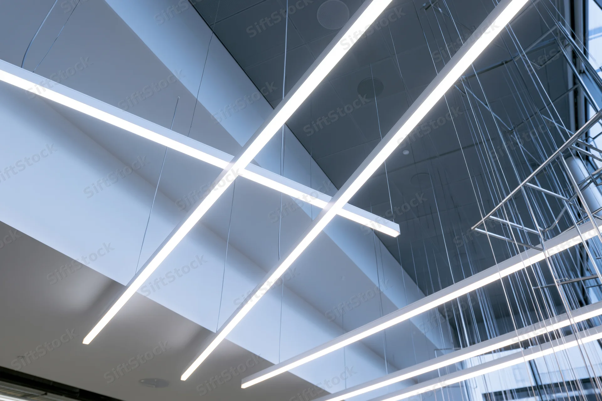 Modern ceiling with linear pendant lights suspended in a public building interior
