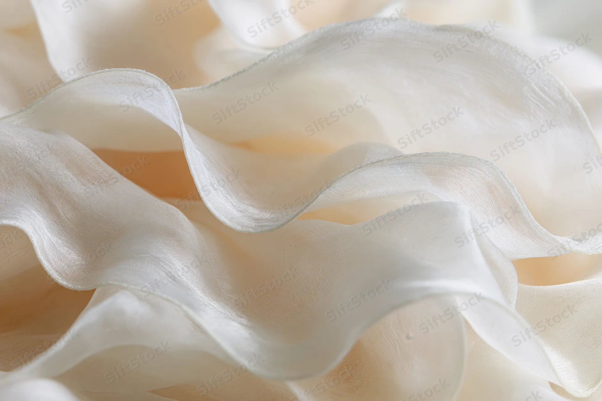 Layers of sheer ivory organza fabric folded and bunched into soft ruffles