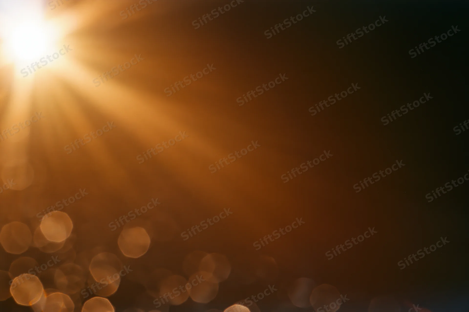 Bright sunburst light source with lens flare and bokeh effect in abstract background