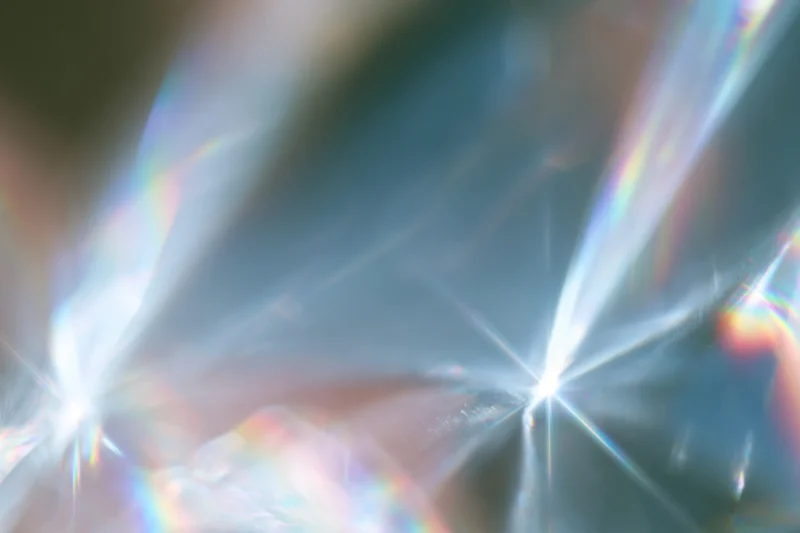 Light refracting through a crystal surface creating rainbow dispersion and starburst flares