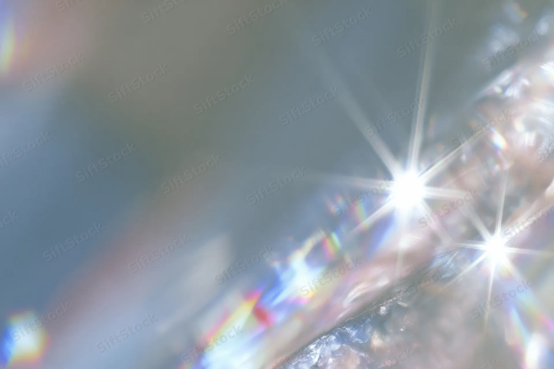 Light refracting through a crystal surface creating starburst and rainbow patterns
