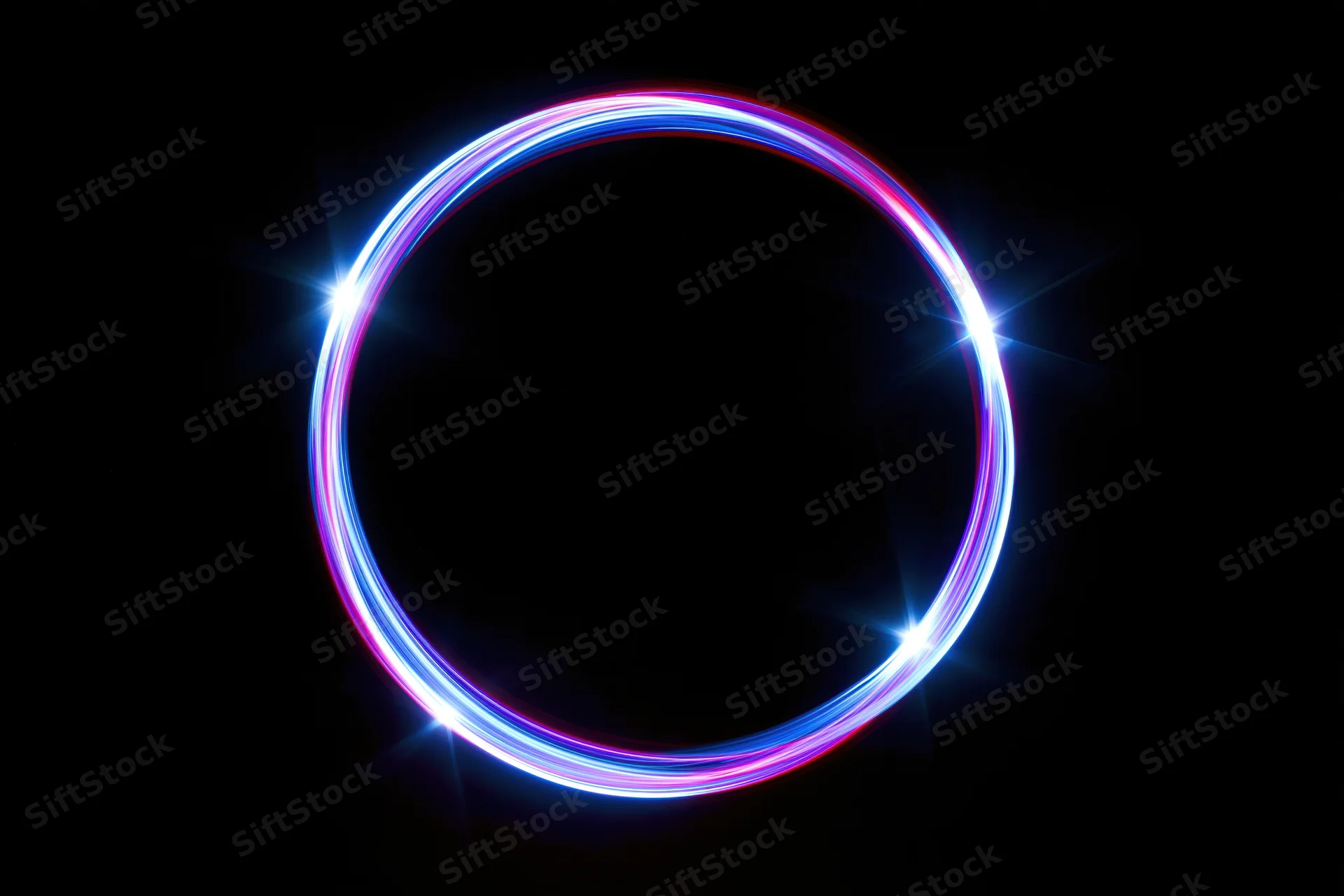 Circular neon light ring glowing brightly against black background with starburst flares