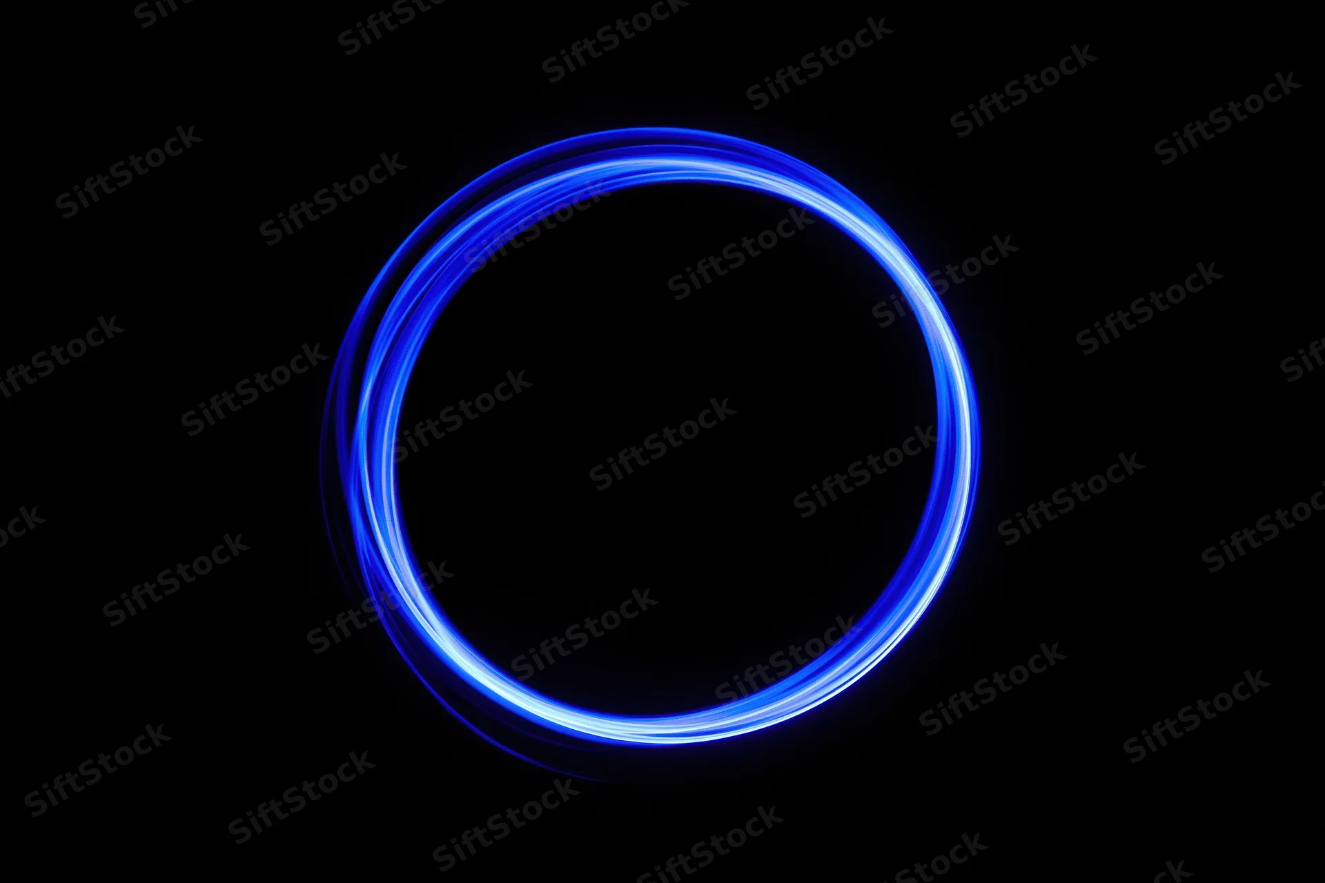Glowing blue circular light trail in dark background from long-exposure light painting photography