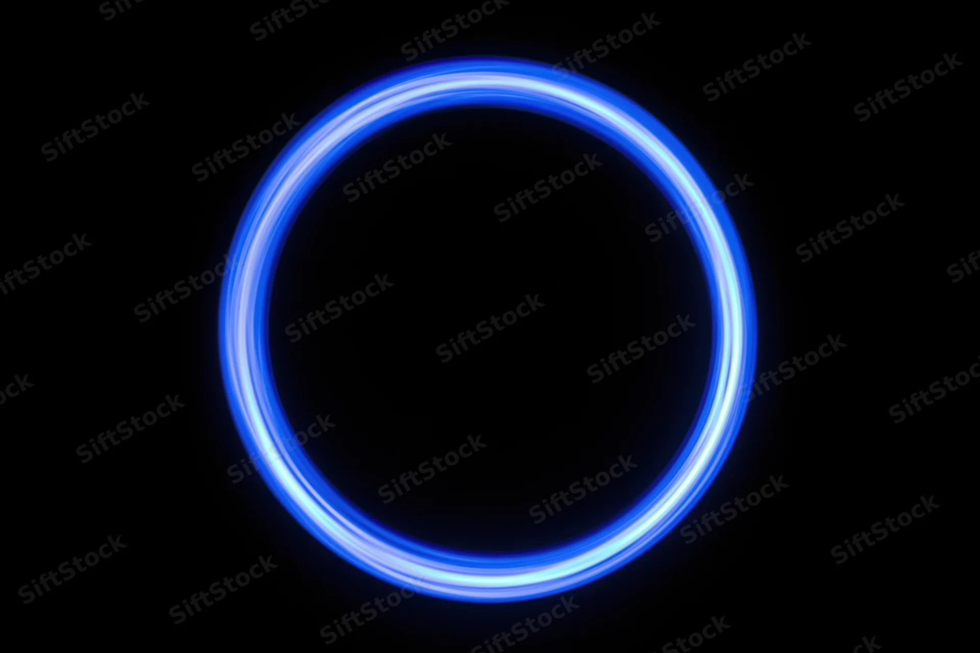 Glowing blue circular light trail against black background from long-exposure light painting photography