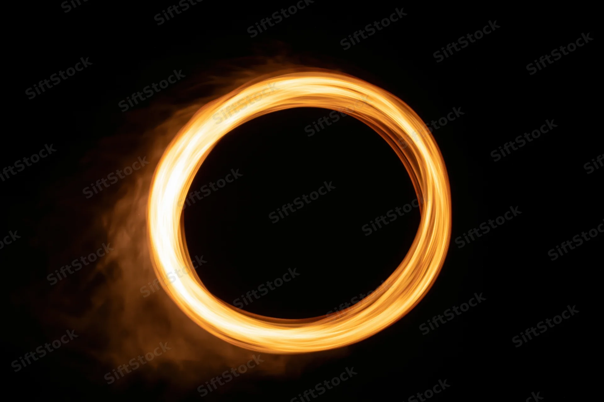 Glowing circular light trail formed by motion in long-exposure photograph against dark background